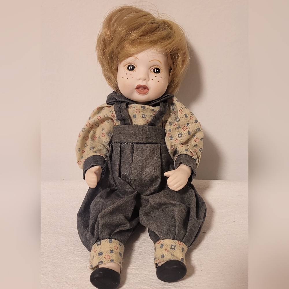 Collectible vintage pre-owned porcelain doll of a little boy with freckles